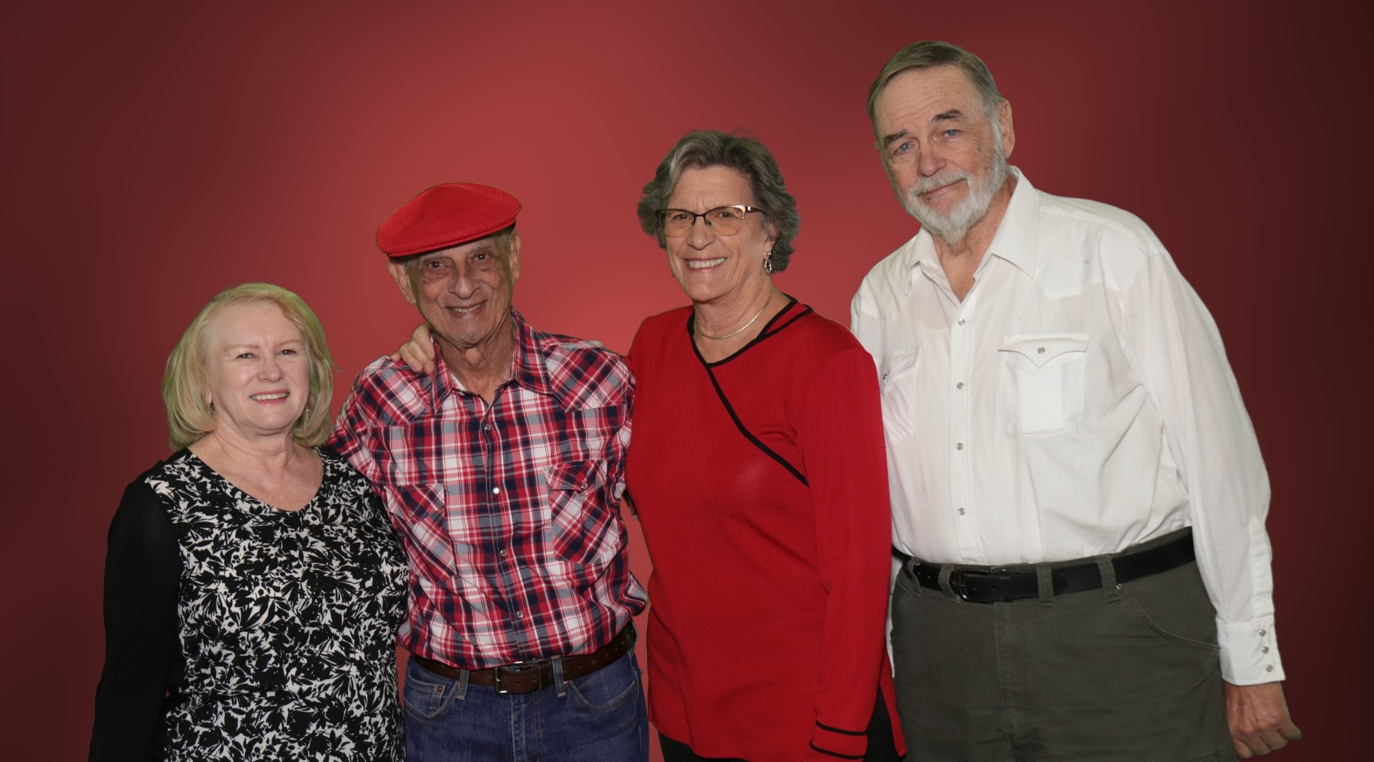 4 OLLI members posing in front of a red background