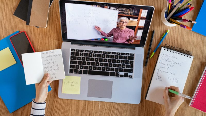 laptop computer on a desktop with an image of a woman teaching a class